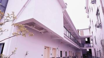 Un estrecho callejón entre edificios, con una estructura de techo plano a la izquierda y un edificio de varios pisos a la derecha.
