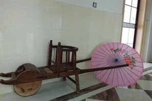 Un chariot en bois sur lequel est fixé un parasol rose.