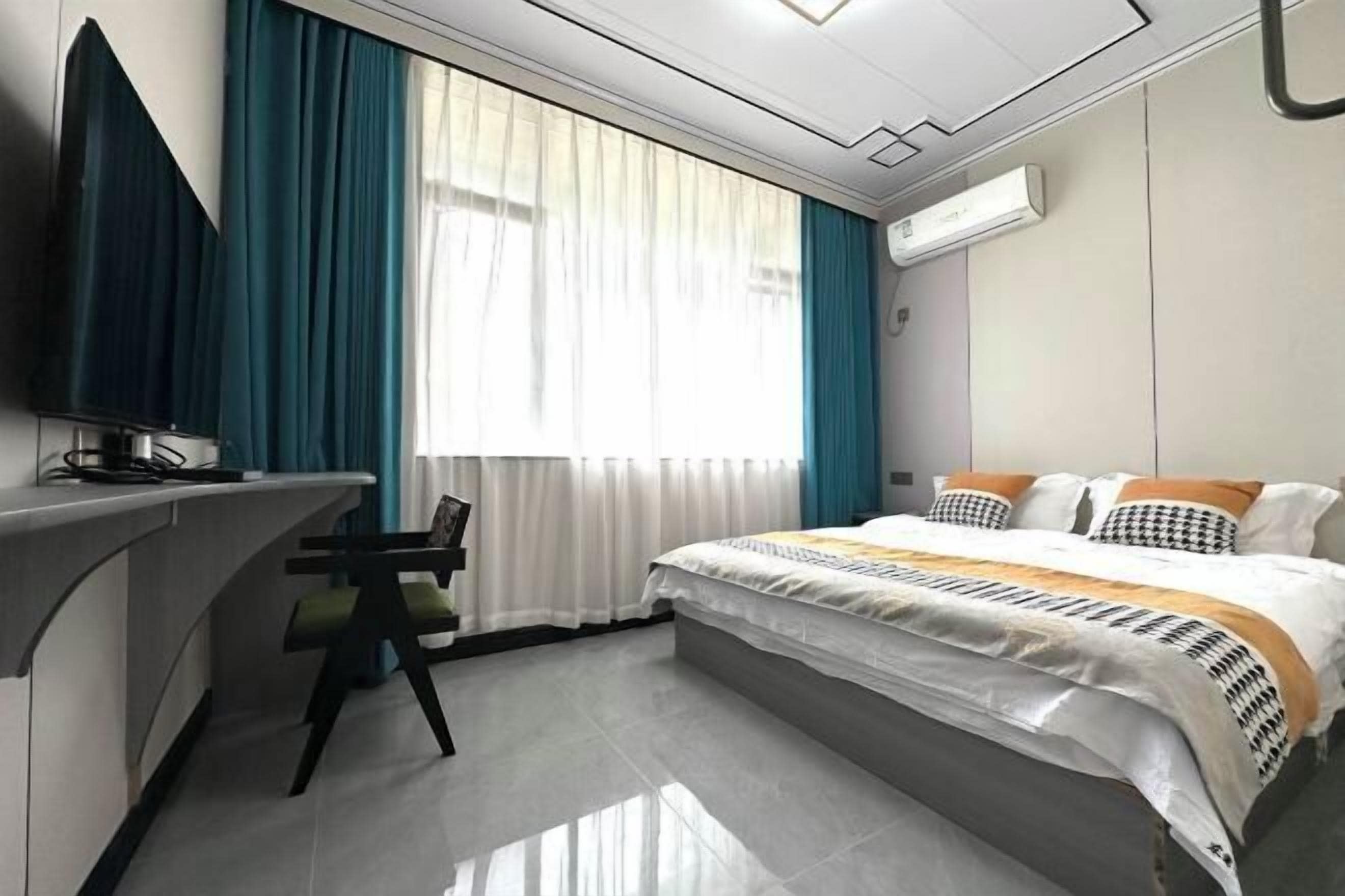 A modern hotel room with a bed, a desk, and a chair.