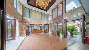 Un hall d’entrée spacieux, doté d’un parquet en point de Hongrie, de grandes fenêtres et d’un comptoir d’accueil.