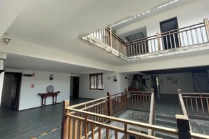 Um interior espaçoso com teto alto, escada de madeira e varanda.