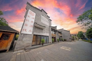 A traditional building with a sign indicating it is a hotel. - Songqin Chinese Inn · Wenquan Homestay (Caotang Millennium Ancient City Tourist Area) (Weng'an County)