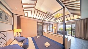 Une chambre d’hôtel avec un grand lit, un bureau et un balcon offrant une vue.