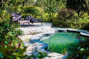 A pool with a curved edge, surrounded by greenery and two lounge chairs. - Songqin Chinese Inn · Wenquan Homestay (Caotang Millennium Ancient City Tourist Area) (Weng'an County)