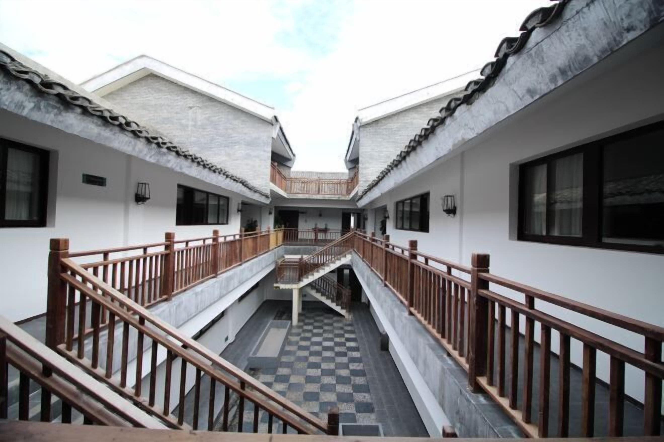 A courtyard with a central staircase connecting two buildings, each with a balcony.