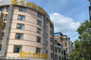 Un edificio de varios pisos con fachada curva, que presenta una serie de ventanas y un letrero llamativo con caracteres chinos.