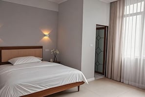 A bedroom with a bed, bedside table, wall-mounted light, and a door with a geometric pattern. - hongdu hotel (Laibin)