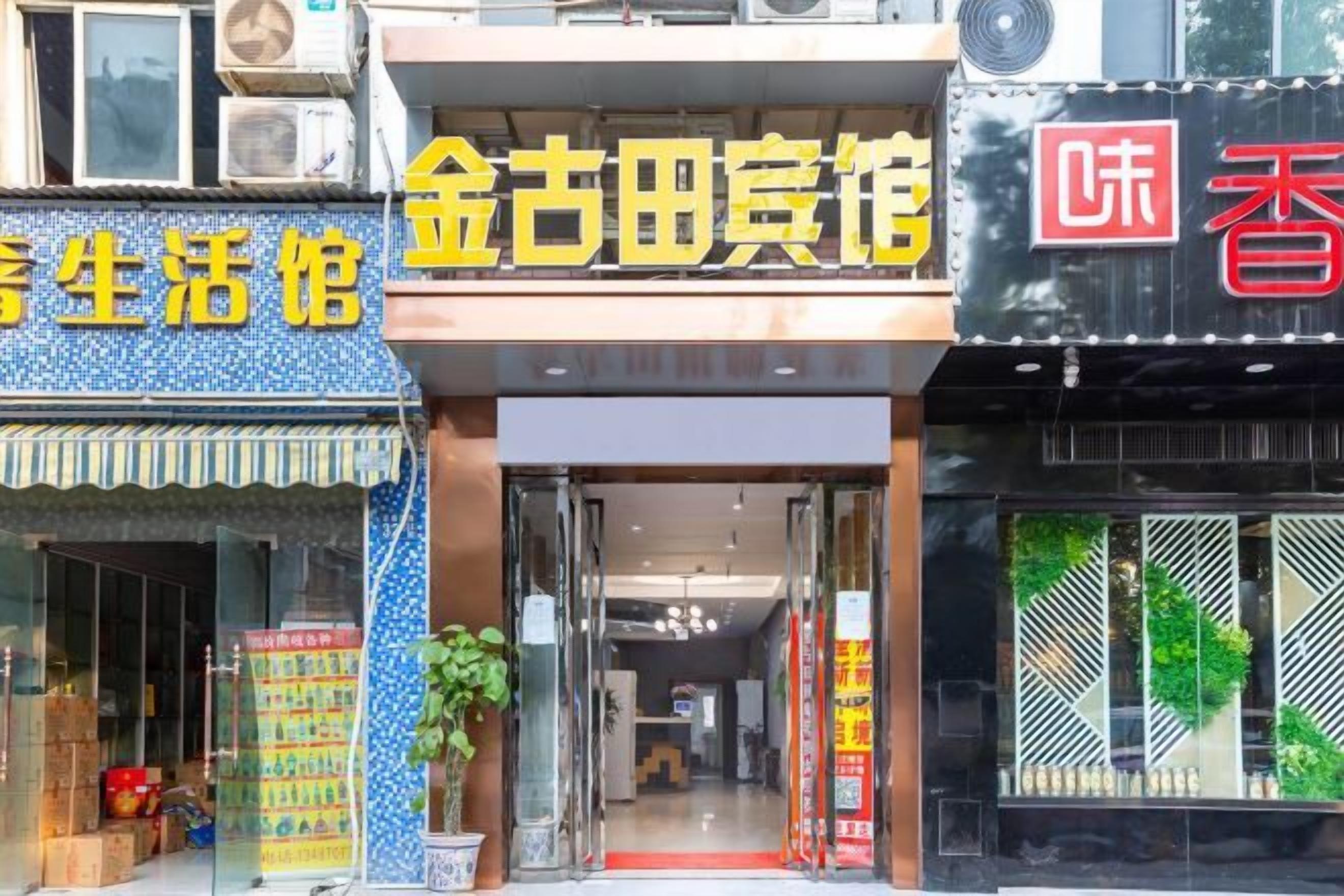 A storefront with a sign that reads '金古田宾馆' and another sign with Chinese characters.