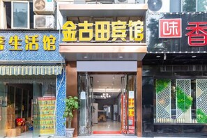 A storefront with a sign that reads '金古田宾馆' and another sign with Chinese characters. - Jin'gutian Hotel (Wuhan)