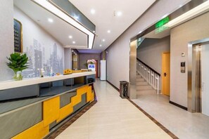 A hotel reception area with a reception desk, a staircase, and an elevator. - Jin'gutian Hotel (Wuhan)