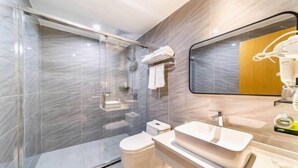Une salle de bain moderne avec une douche à parois de verre, des toilettes, un lavabo et un miroir.