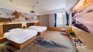 Une chambre d’hôtel moderne avec un grand lit, des tables de chevet, un bureau et un grand tableau au mur.