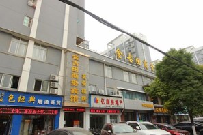 A multi-story building with commercial establishments on the ground floor, including a hotel and various shops. - Jin'gutian Hotel (Wuhan)