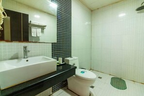 A bathroom with a white sink, black countertop, white toilet, and a mirror with a towel rack. - Jin'gutian Hotel (Wuhan)