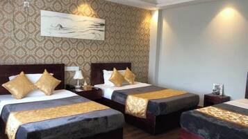 A hotel room with two beds, a large painting on the wall, and a patterned wallpaper.