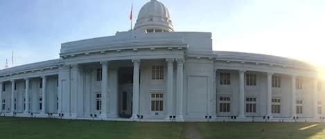 A large, white, neoclassical building with a central dome and columns, likely a government or historical building.