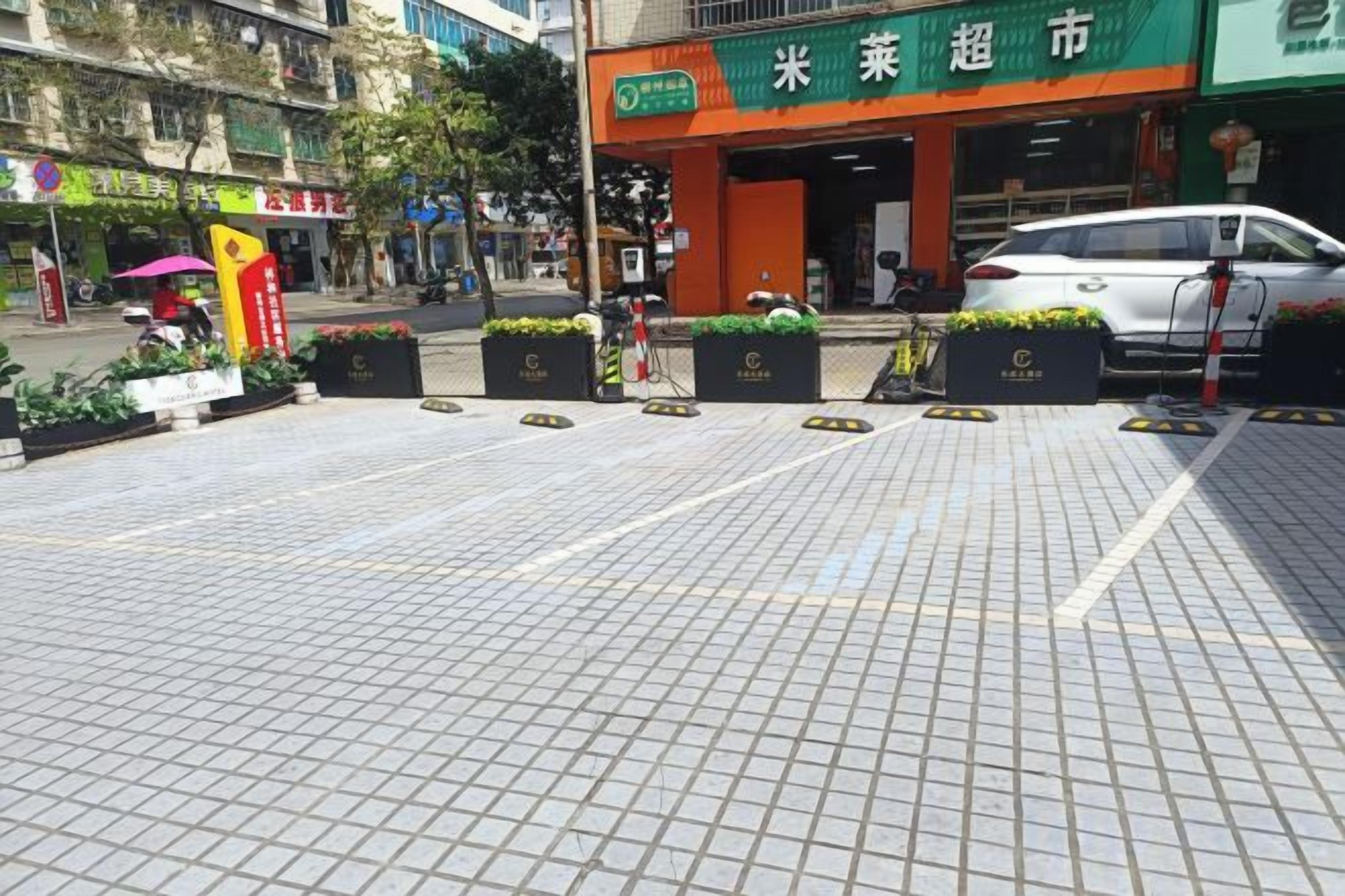 A paved outdoor area with planters and a storefront.