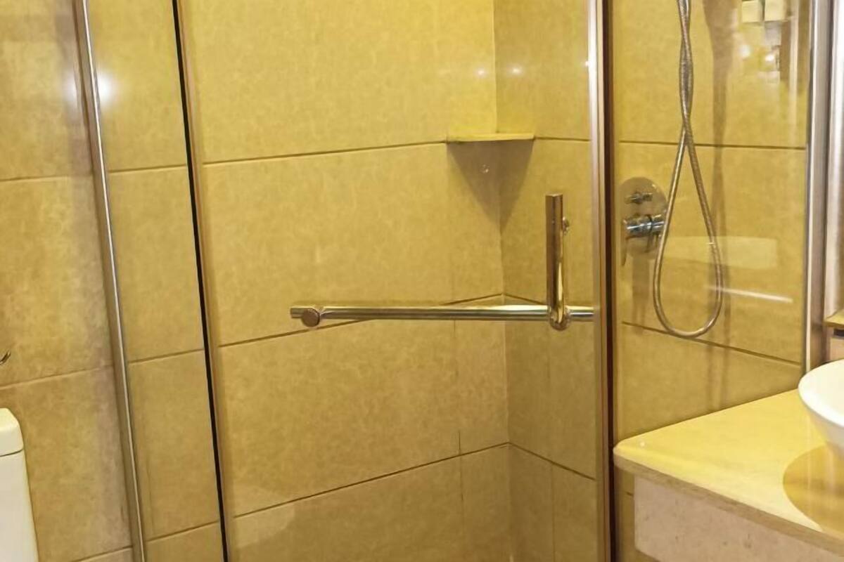 Un espace douche doté d’une porte en verre, d’un porte-serviettes et d’un pommeau de douche.