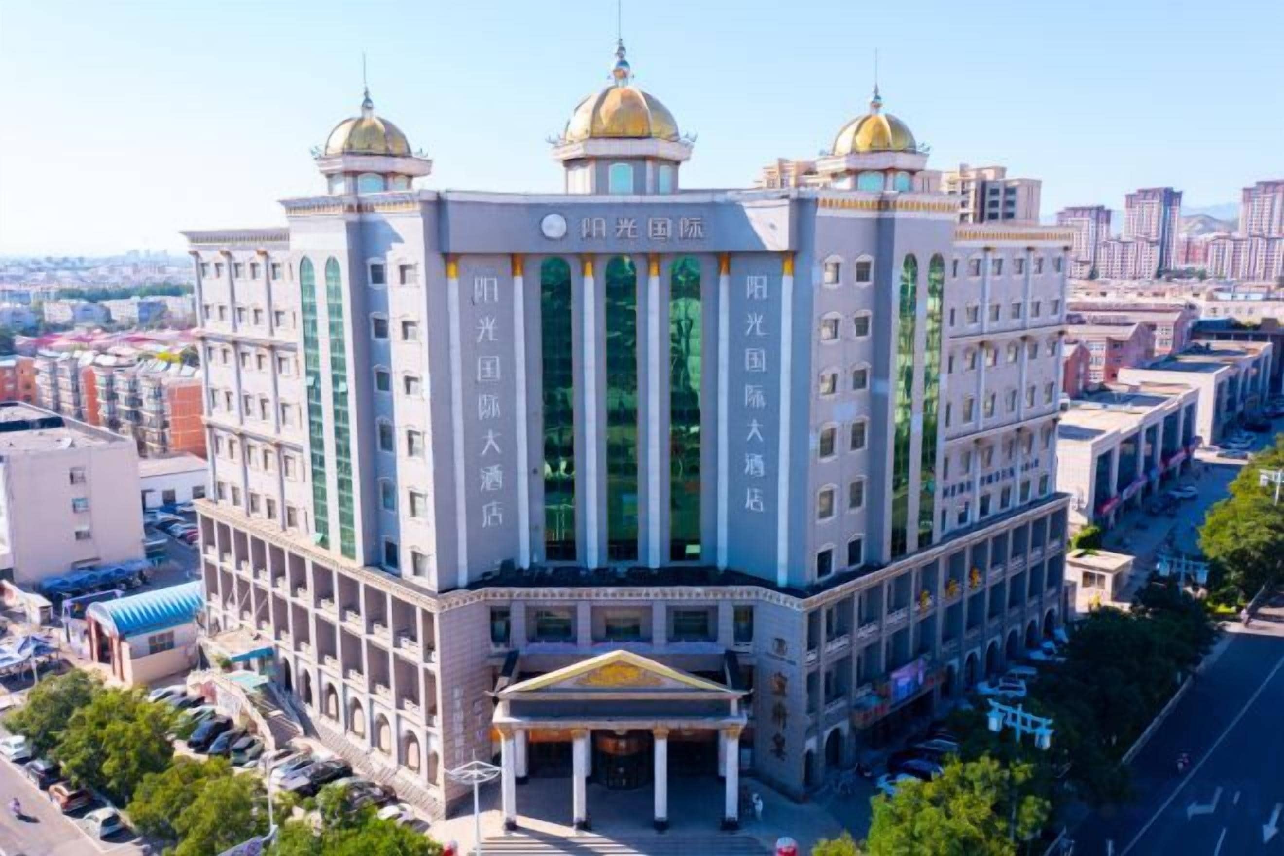 A multi-story building with a central entrance, large windows, and a symmetrical facade.