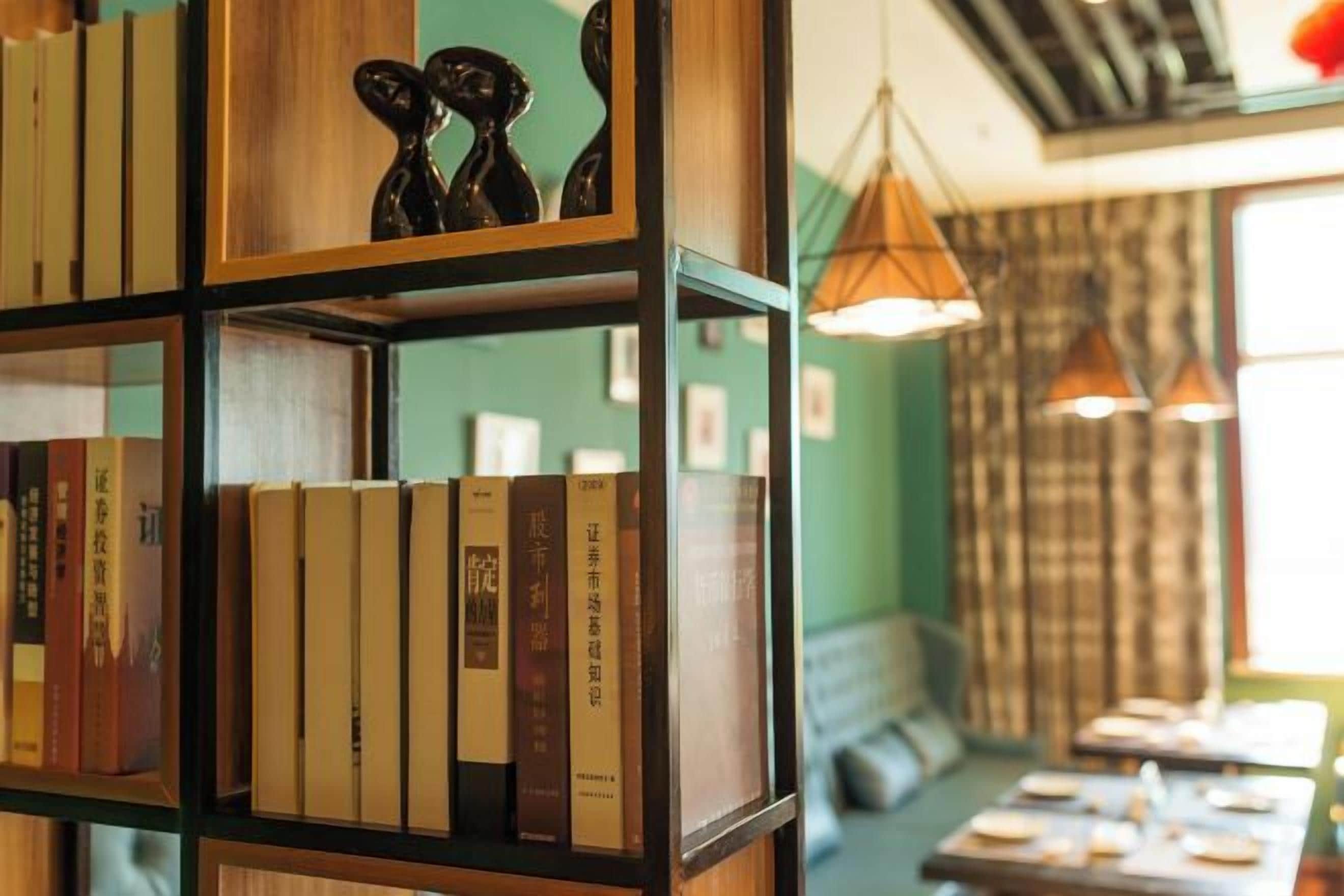 A bookshelf with books, a sofa, and a table with items on it.