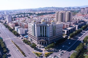 A multi-story building with a central courtyard, surrounded by roads and other buildings.