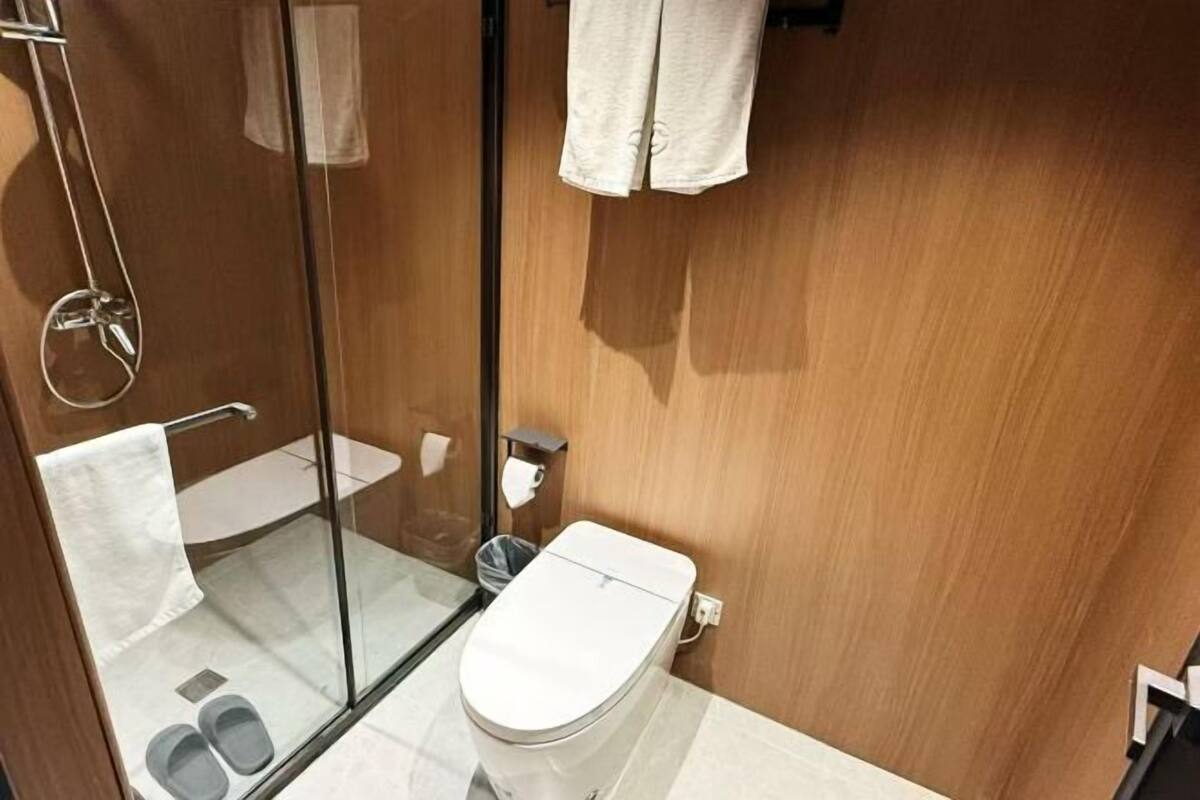 Un baño pequeño con cabina de ducha de vidrio, inodoro y lavamanos.