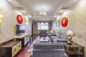 A living room with a sofa, TV, and decorative items.