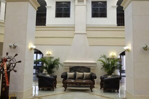 Eine Lobby mit zwei Sofas, einem Chandelier und einer großen Säule.