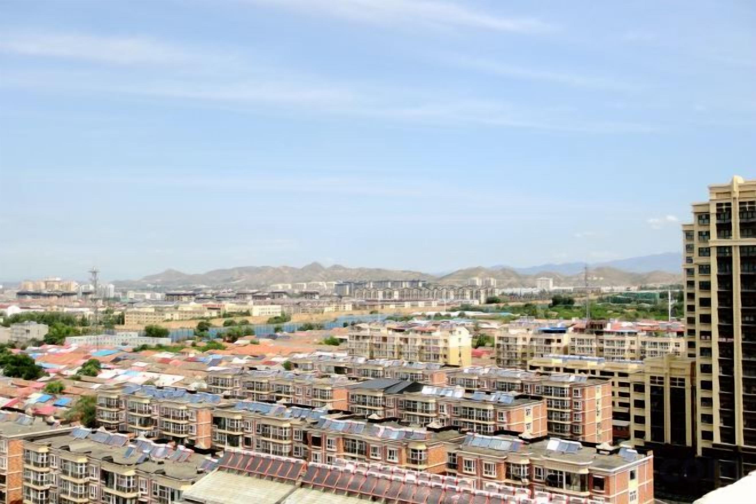 A residential area with multiple buildings, including a tall apartment building on the right.