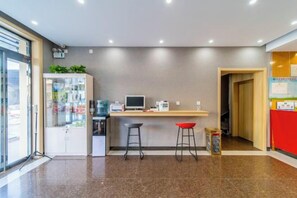 Un área de cocina moderna con mostrador, taburetes y refrigerador.