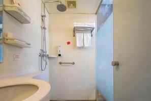 A bathroom with a toilet, a shower, and a towel rack.