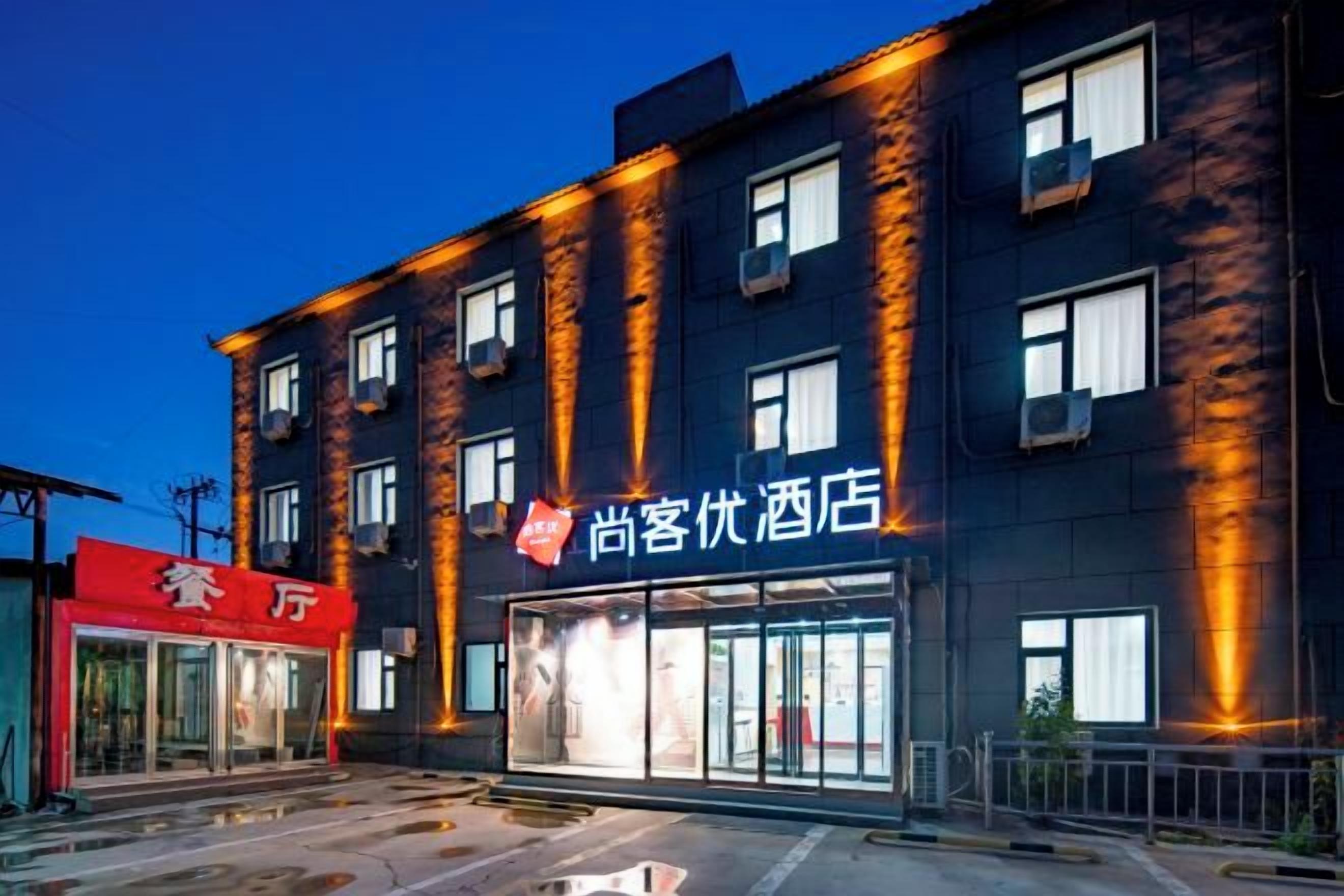 A hotel with a prominent sign, multiple windows, and a visible entrance.