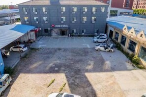 Un edificio de varios pisos con un estacionamiento al frente.