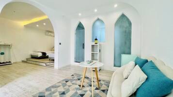 A modern living room with a sofa, a patterned rug, and a small table.
