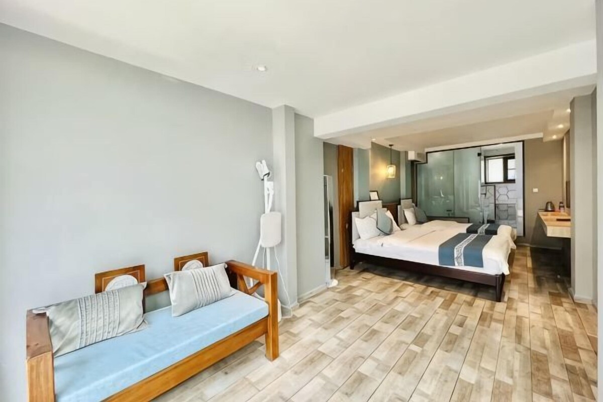 A modern bedroom with a wooden bed, a sofa, and a large mirror.