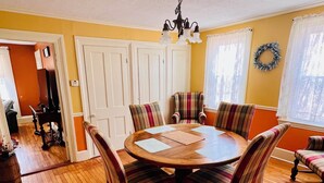 A dining room with a wooden table and plaid chairs, a chandelier, and a view of the adjacent living room. - Home Away from Home- Discover Comfort and Convenience in this 4 Bedroom Home  (Holden)