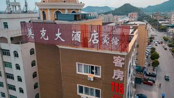 A hotel building with a sign indicating room rates.