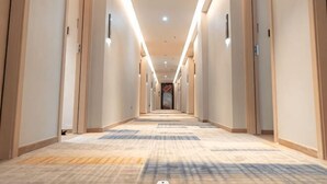 A long, well-lit hallway with carpeted floors and doors on both sides. - Meike Hotel (Wenzhou)