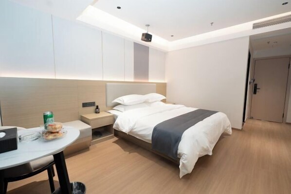 A modern hotel room with a bed, bedside table, and a small desk with a chair. - Meike Hotel (Wenzhou)