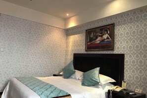 A hotel room with a bed, a nightstand, a telephone, and a painting on the wall. - Meike Hotel (Wenzhou)
