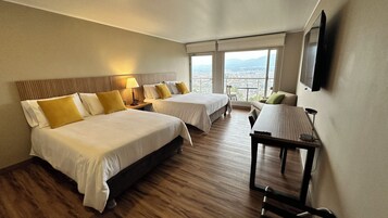 Una habitación de hotel con dos camas, una mesa, una silla y un televisor.