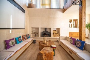 Un amplio salón con chimenea, asientos y una mesa de centro de madera.