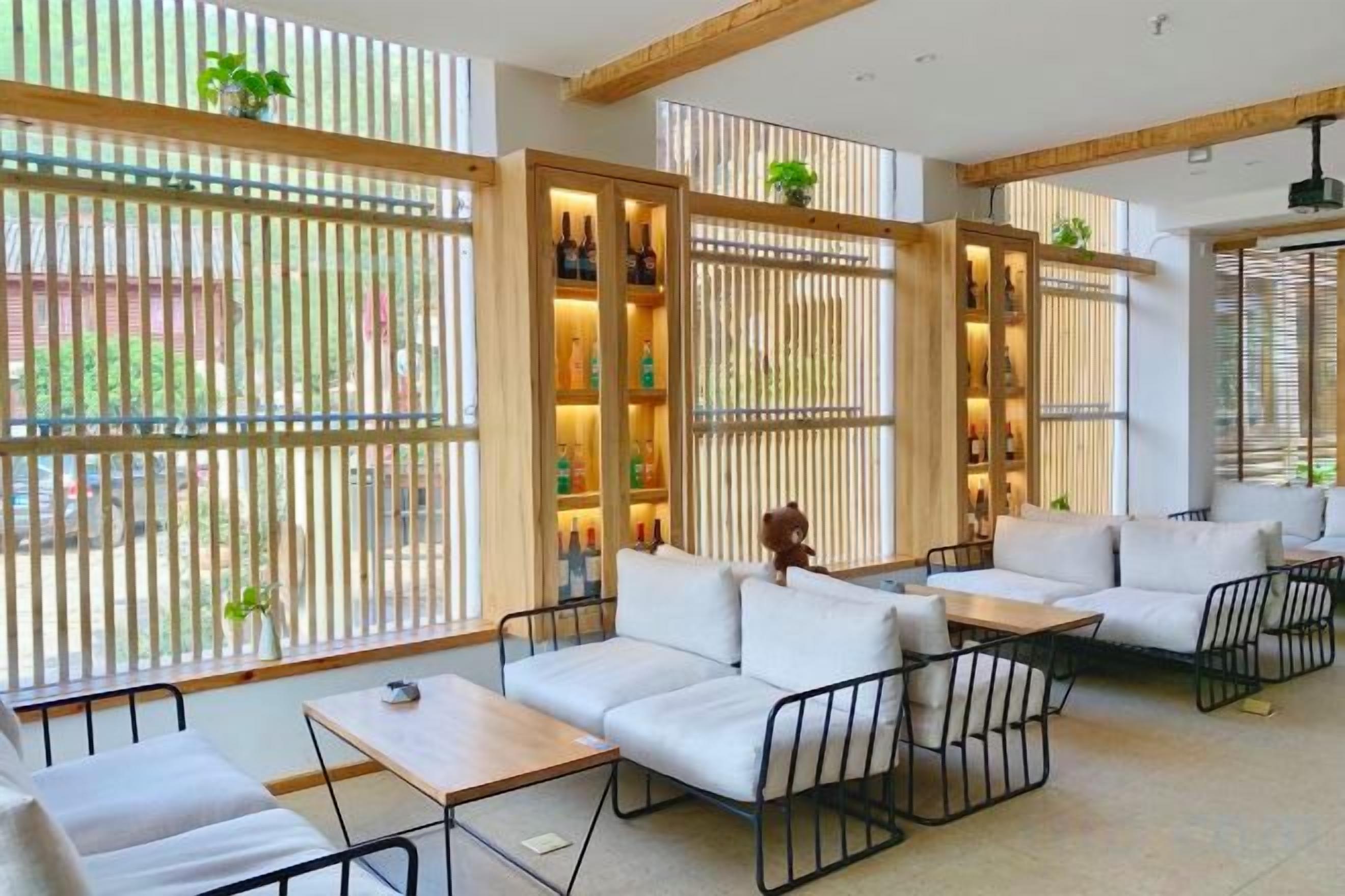 Een modern interieur met een modulaire bank, een bijzettafeltje en een zithoek met uitzicht door een houten scheidingswand.