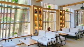 Een modern interieur met een modulaire bank, een bijzettafeltje en een zithoek met uitzicht door een houten scheidingswand.