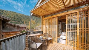 Eine Holzterrasse mit einem traditionellen japanischen Raum, komplett mit Tatami-Matten und verschiebbaren Türen.