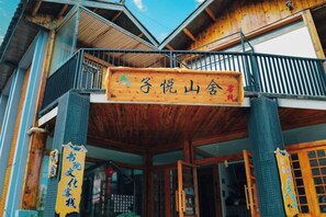 A traditional wooden building with a balcony and signage indicating a cultural or historical site. - Lugu Huzi yueshanshe Inn (Ninglang)