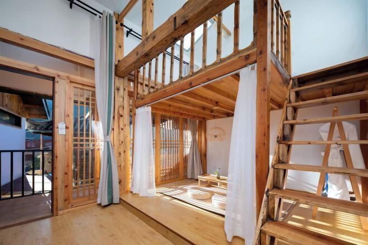 Una habitación tradicional japonesa con suelo de tatami, vigas de madera y puertas correderas.