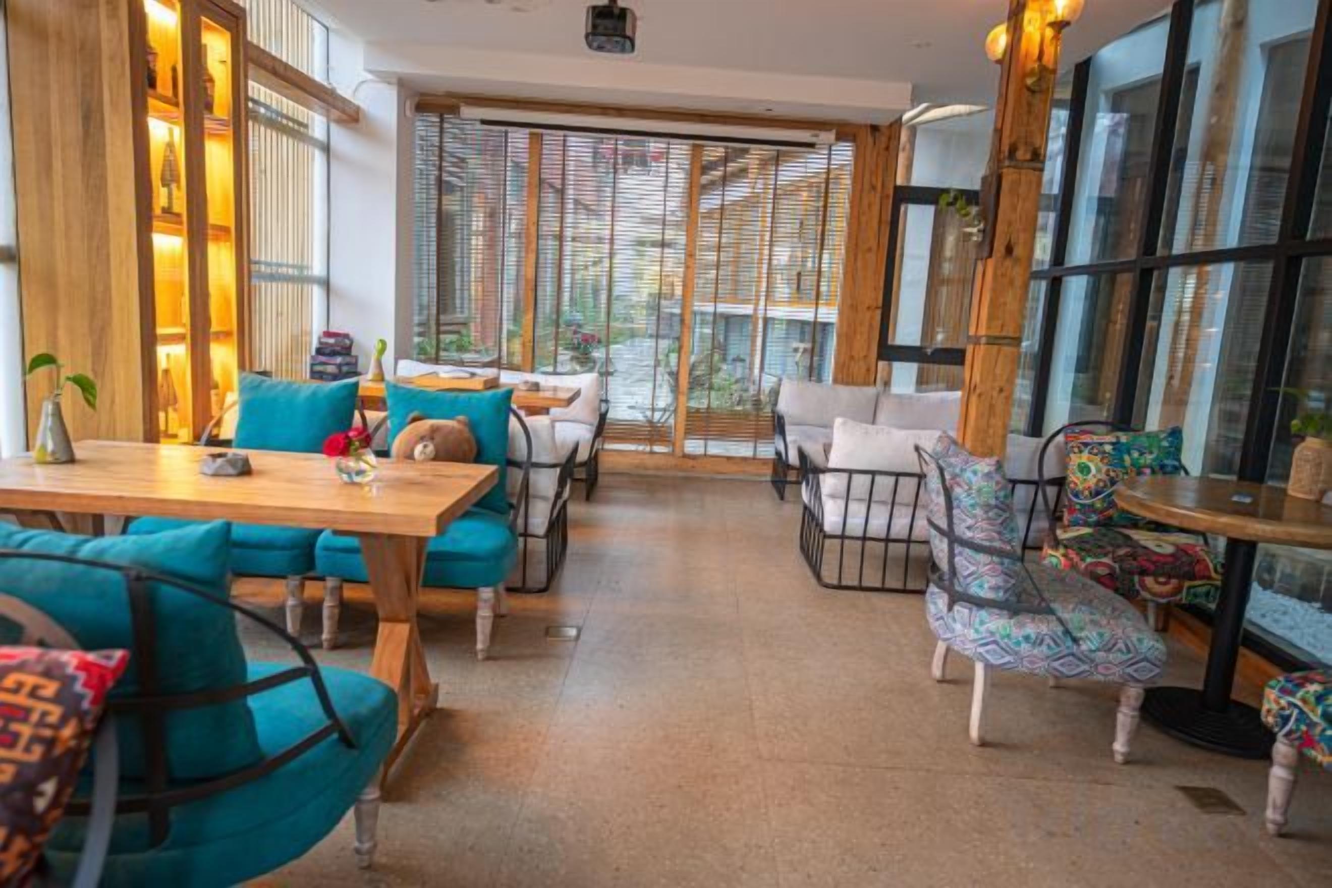 Een modern interieur met houten meubels, een glazen deur naar buiten en uitzicht op de omgeving.