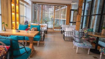 Een modern interieur met houten meubels, een glazen deur naar buiten en uitzicht op de omgeving.
