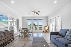 Relax in a spacious living area with a large flat-screen TV, sofa, and two chairs.